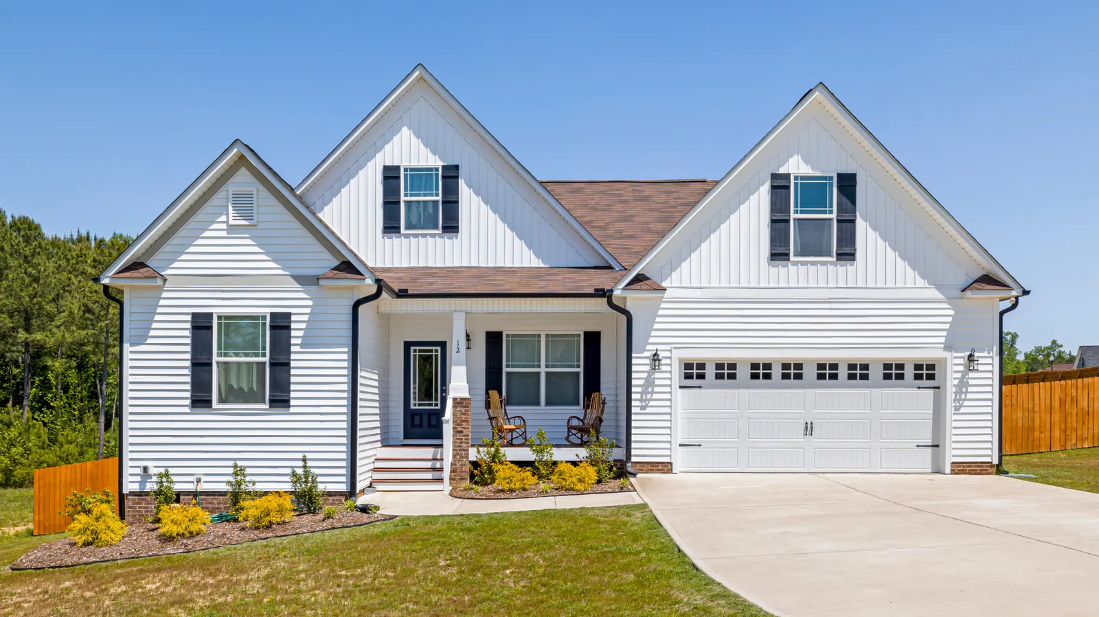 Brown shingle roof on a white home with attached two-car garage