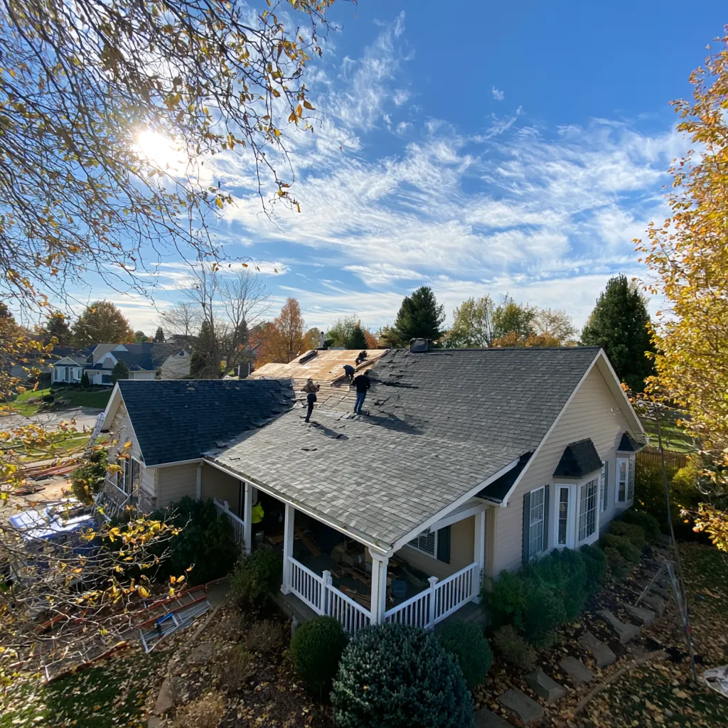 Roofers stripping shingles on a house roof seen from above